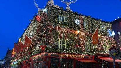 A photograph taken facing Temple Bar pub. It is decorated heavily for Christmas